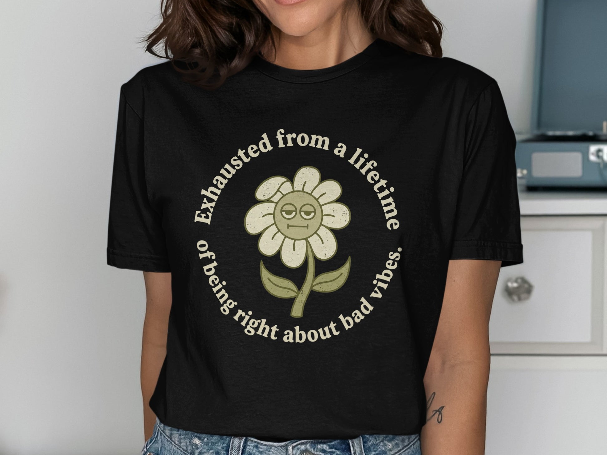 Black t-shirt with a distressed flower graphic and text: Exhausted from a lifetime of being right about bad vibes.
