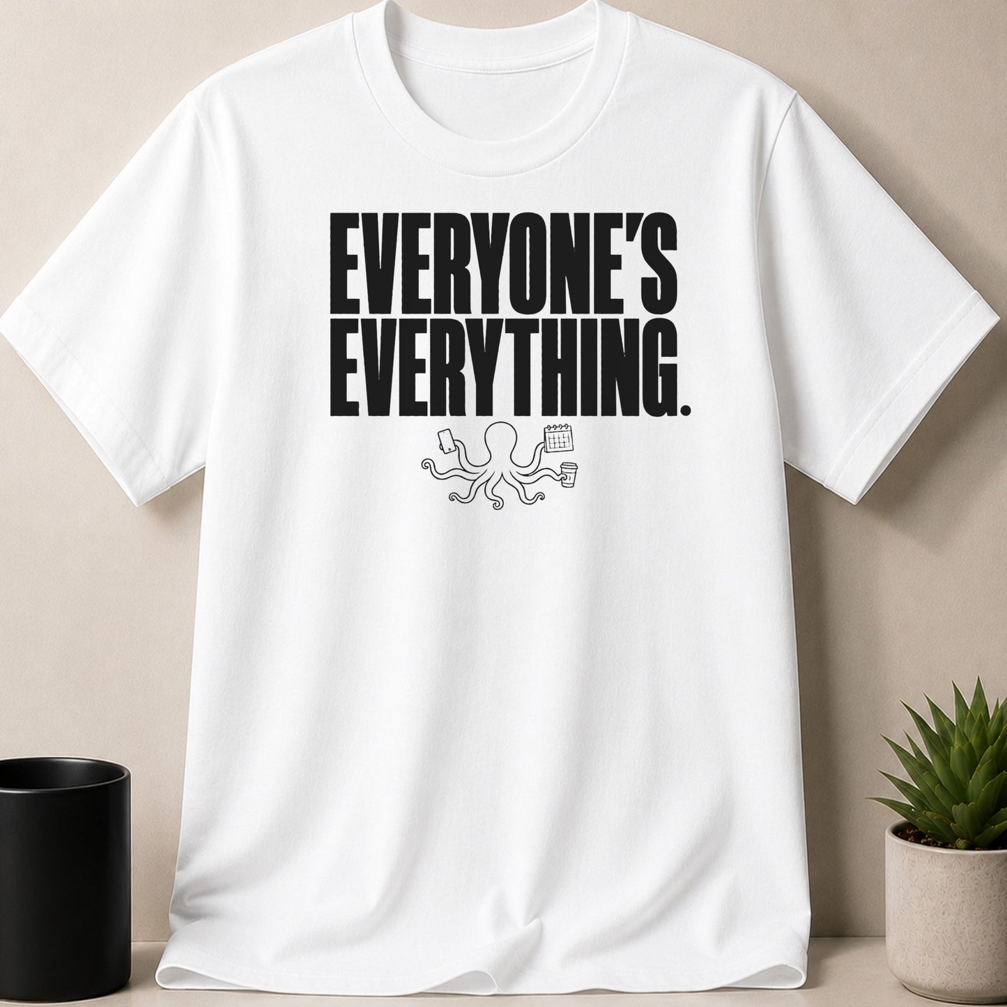 White t-shirt with black text "EVERYONE'S EVERYTHING" and an octopus holding items.