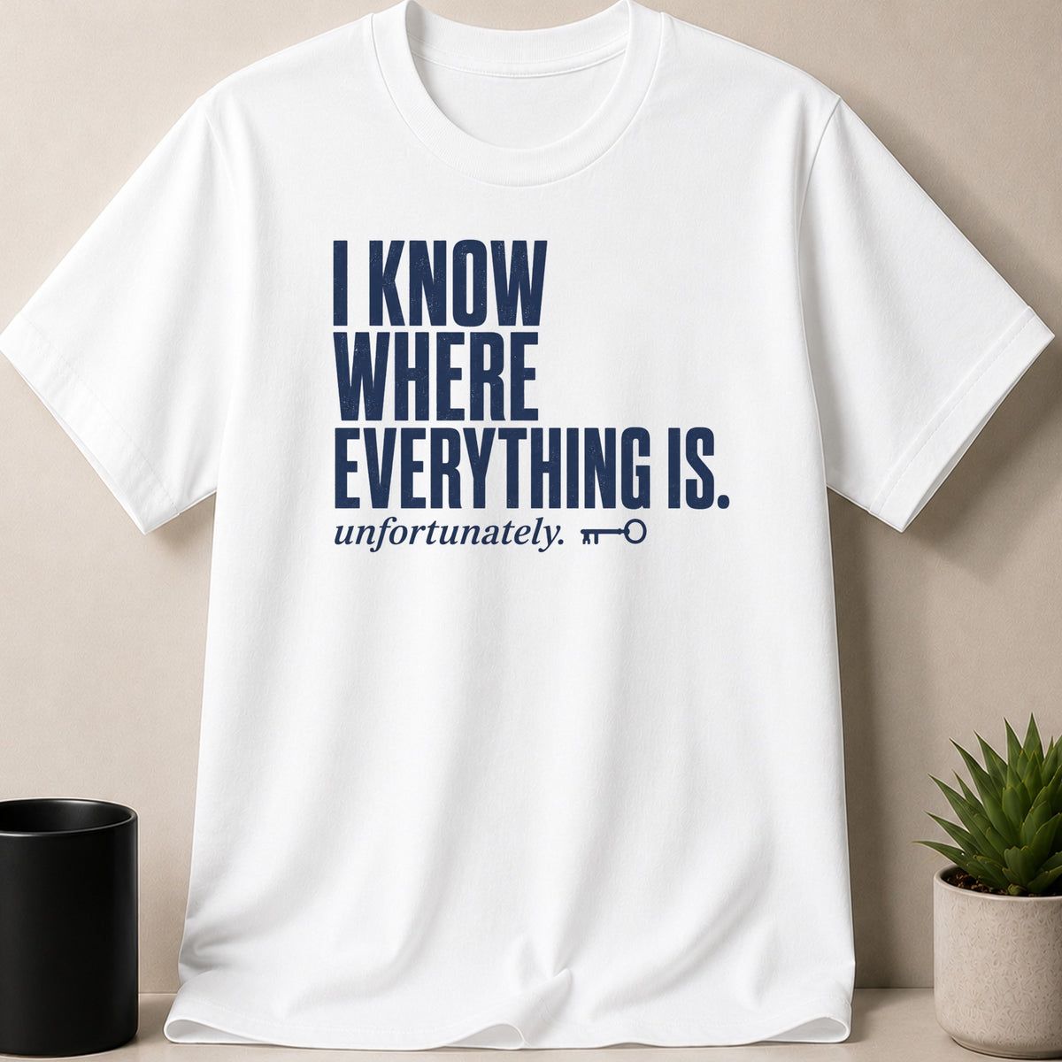 White t-shirt with navy text "I KNOW WHERE EVERYTHING IS. unfortunately." and a key graphic.