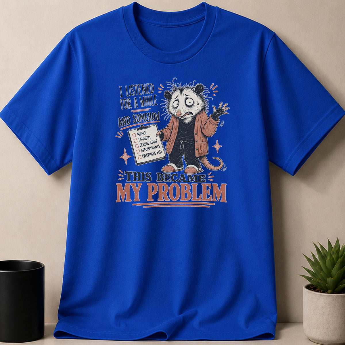 Blue t-shirt with distressed graphic of an opossum holding a checklist and text "This Became My Problem".