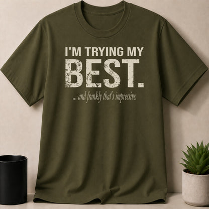 Olive green t-shirt with distressed white text "I'M TRYING MY BEST. ...and frankly that's impressive."