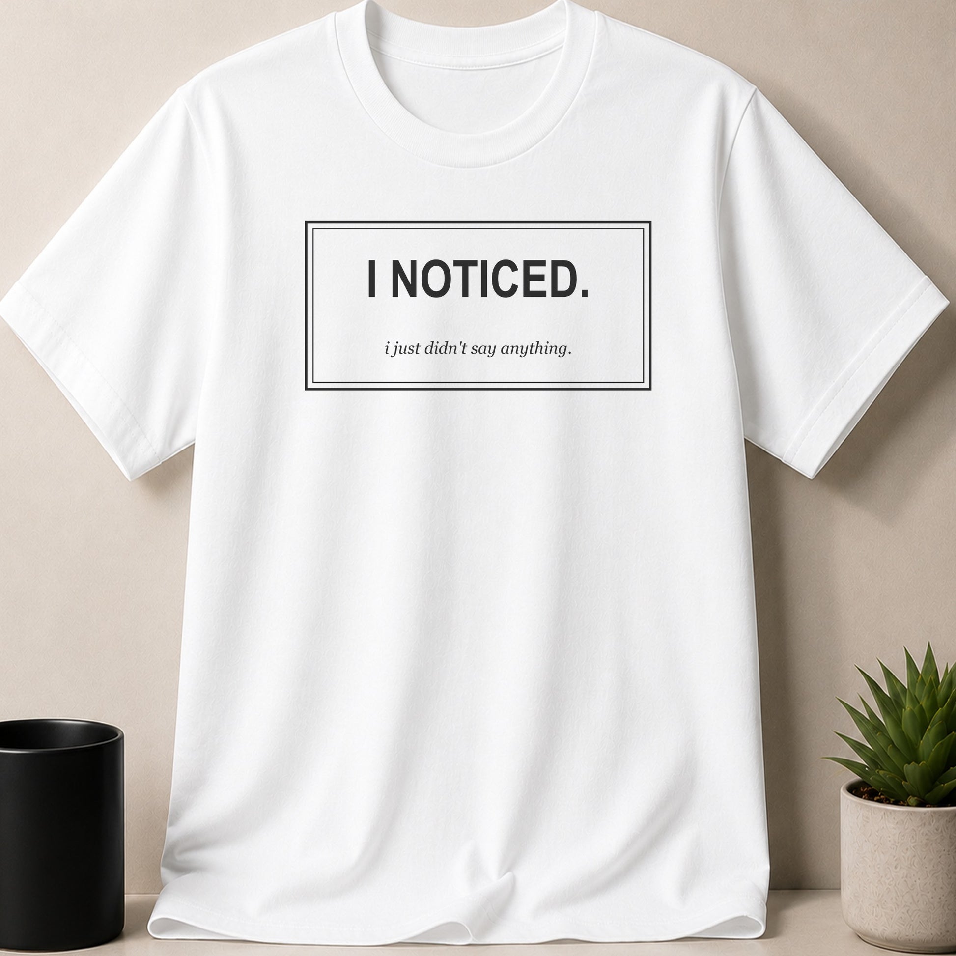 White t-shirt with black text: "I NOTICED. i just didn't say anything."