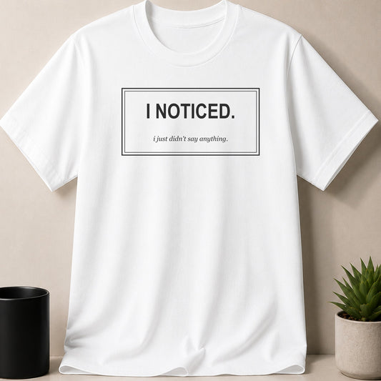 White t-shirt with black text: "I NOTICED. i just didn't say anything."
