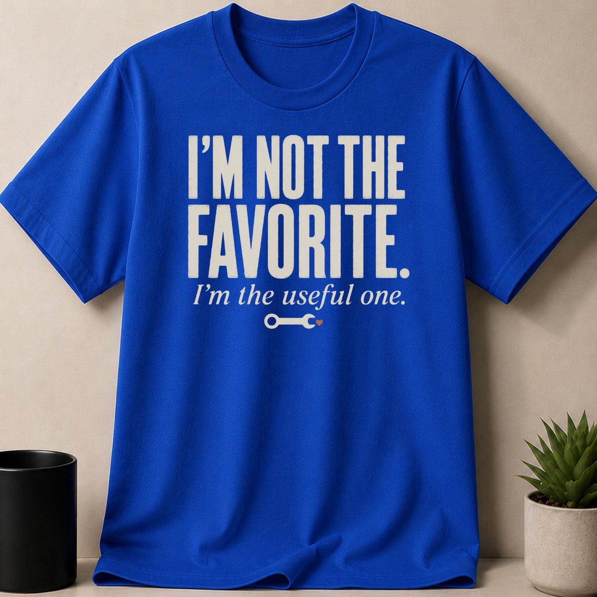Blue t-shirt with text "I'm not the favorite. I'm the useful one." and a wrench graphic.
