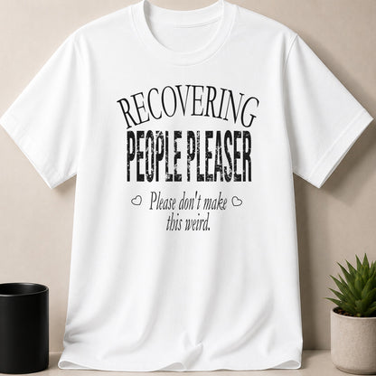 White t-shirt with black text "RECOVERING PEOPLE PLEASER Please don't make this weird."