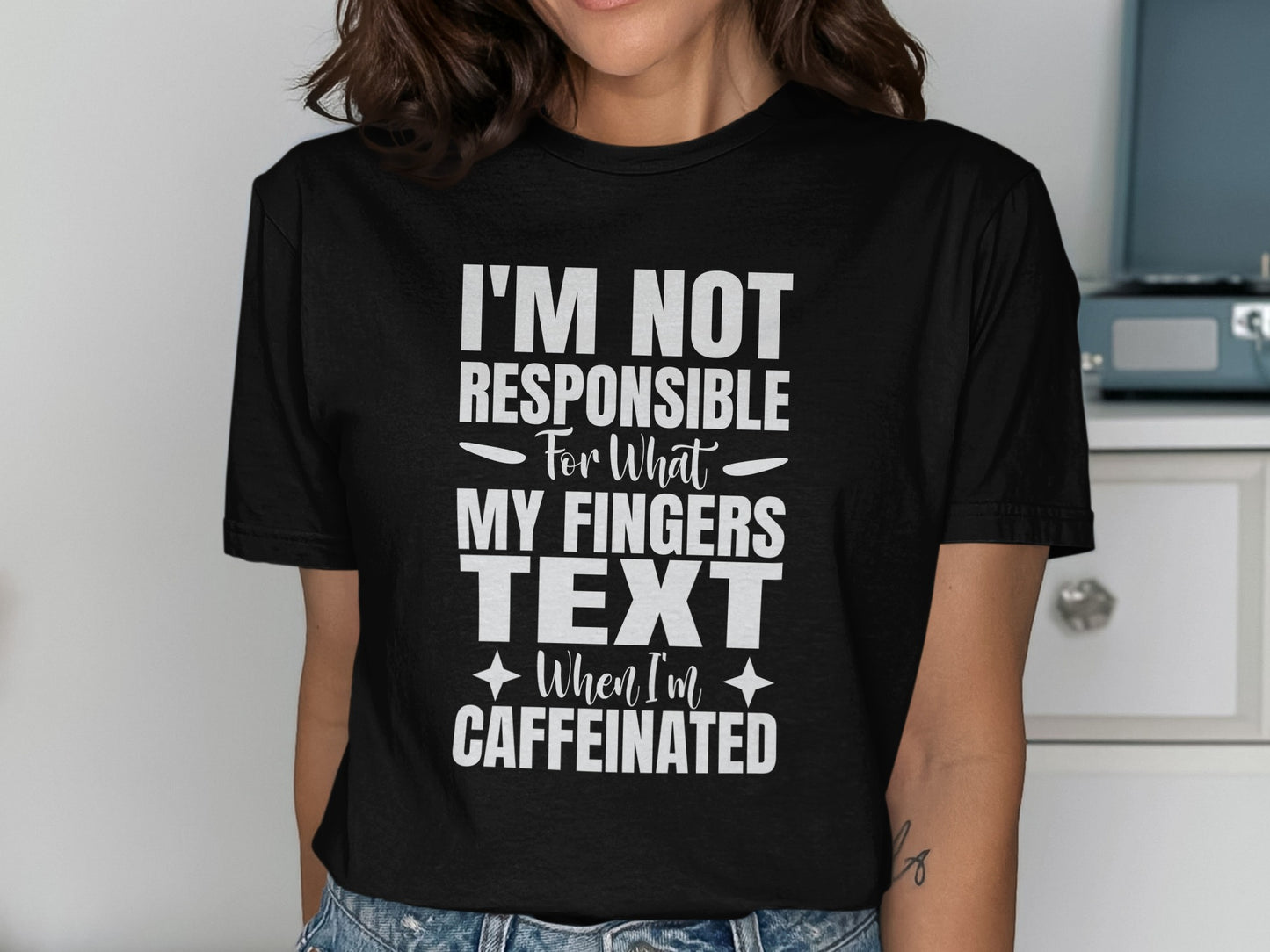 Black t-shirt with white text: I'm Not Responsible For What My Fingers Text When I'm Caffeinated.