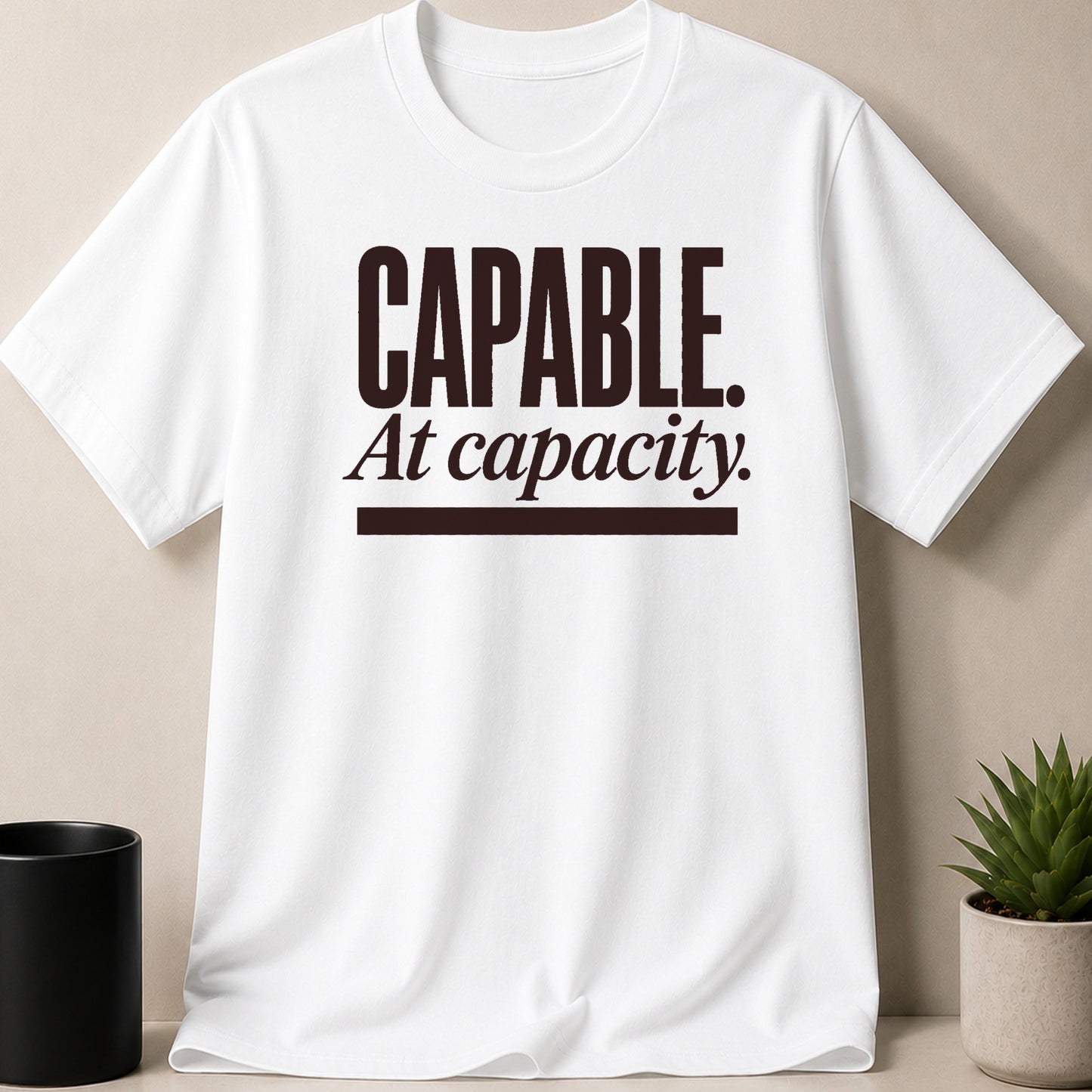 White t-shirt with brown text "CAPABLE. At capacity."