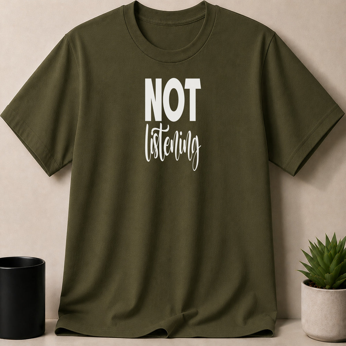 Olive green t-shirt with white text that reads "NOT listening".