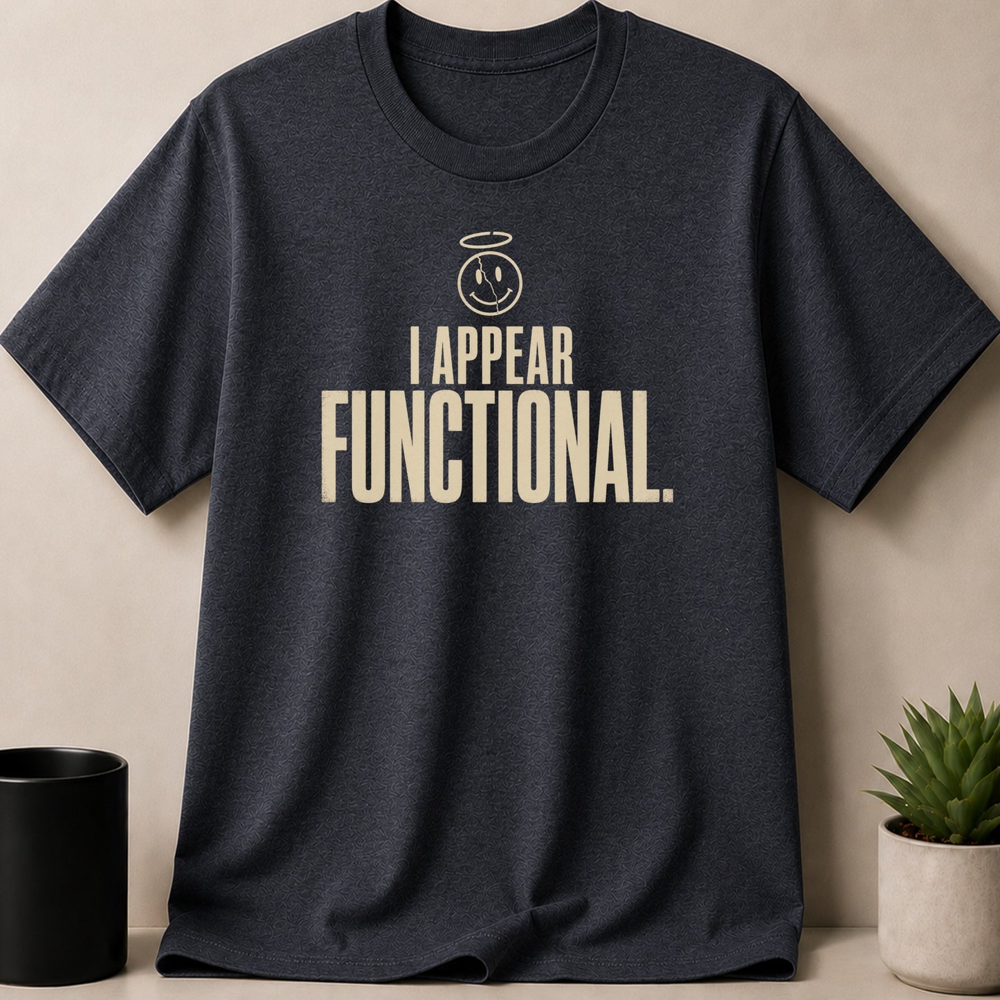 Dark charcoal t-shirt with "I APPEAR FUNCTIONAL." text and cracked smiley face graphic.