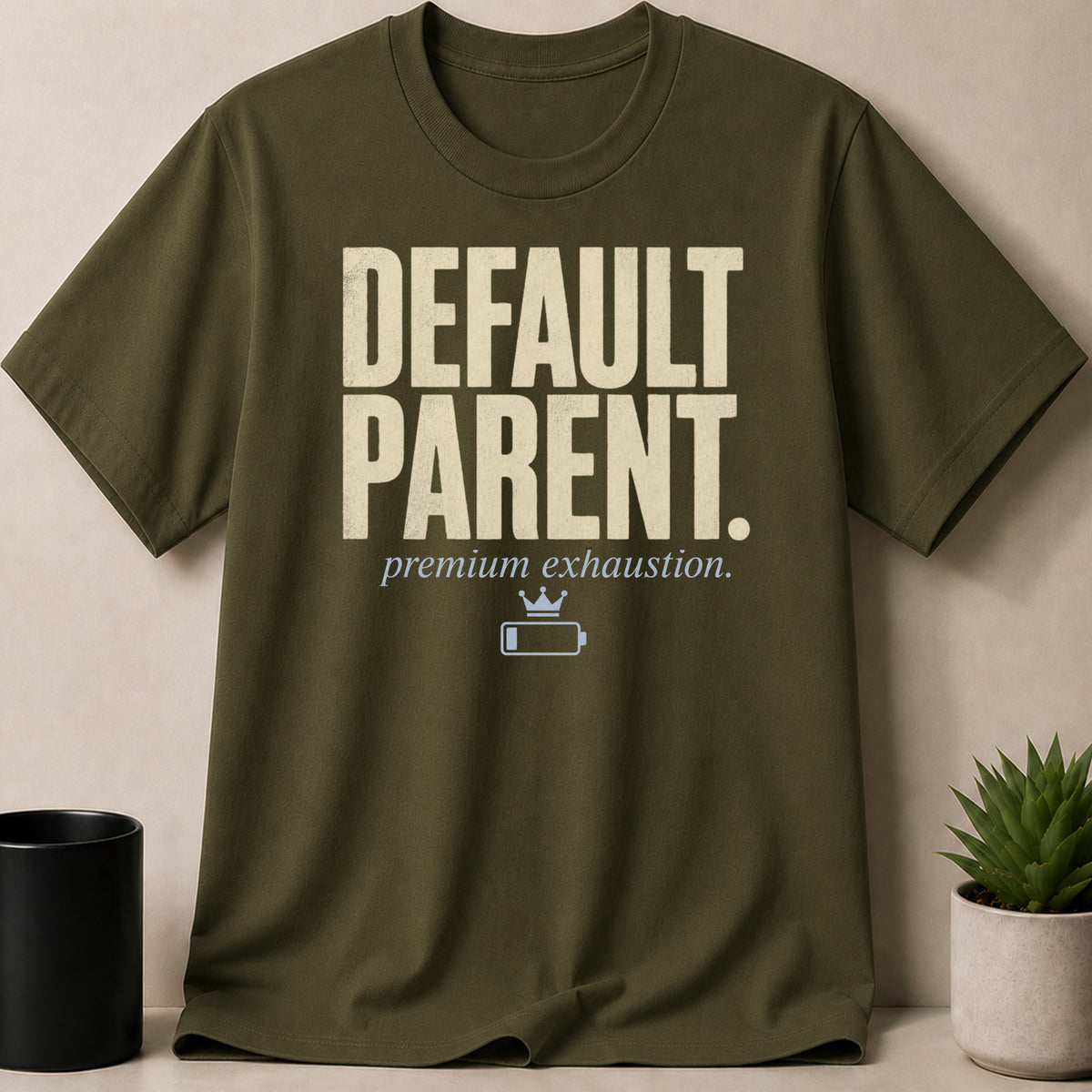 Olive green t-shirt with "DEFAULT PARENT. premium exhaustion." text and battery icon.
