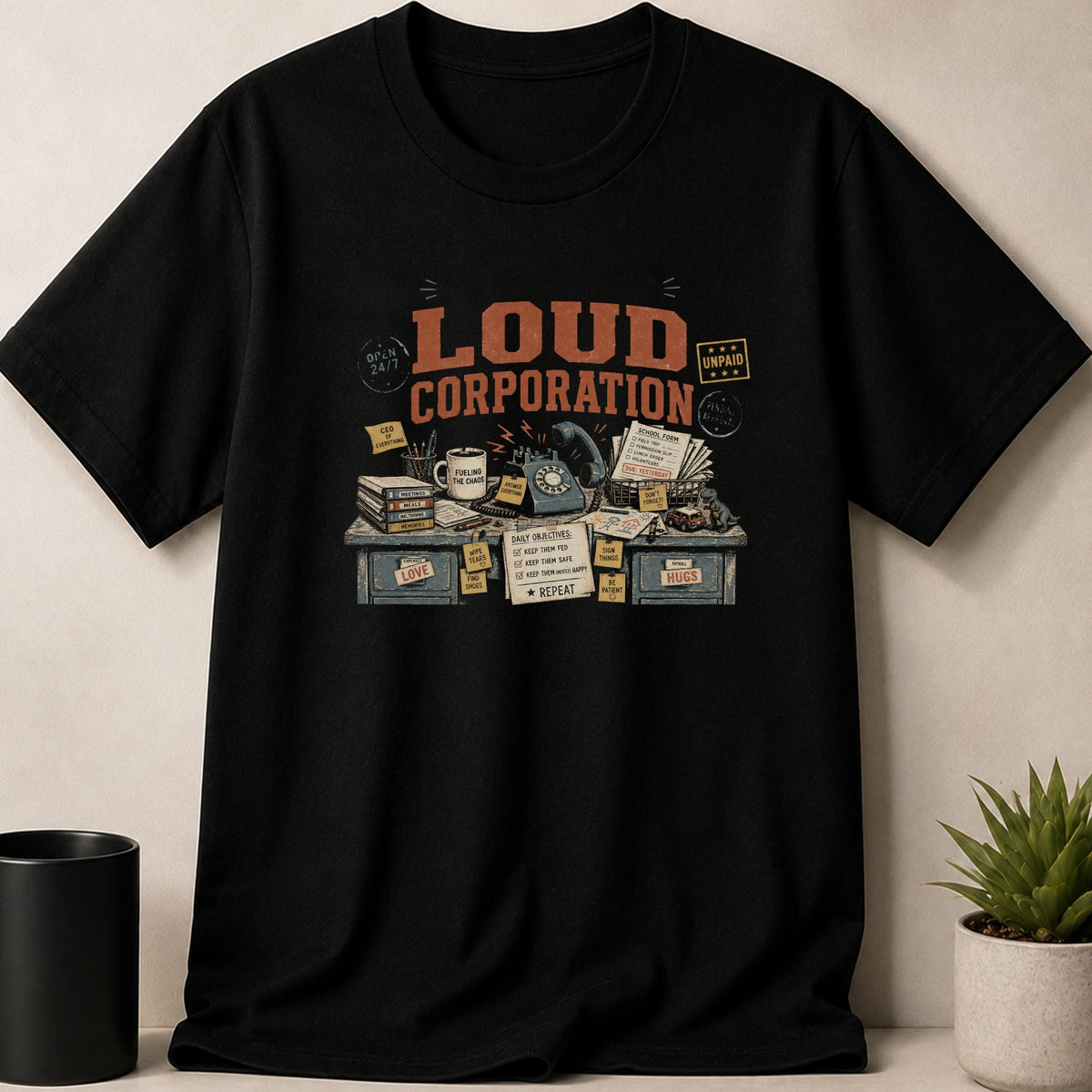 Black t-shirt with "Loud Corporation" design featuring a desk of office items.