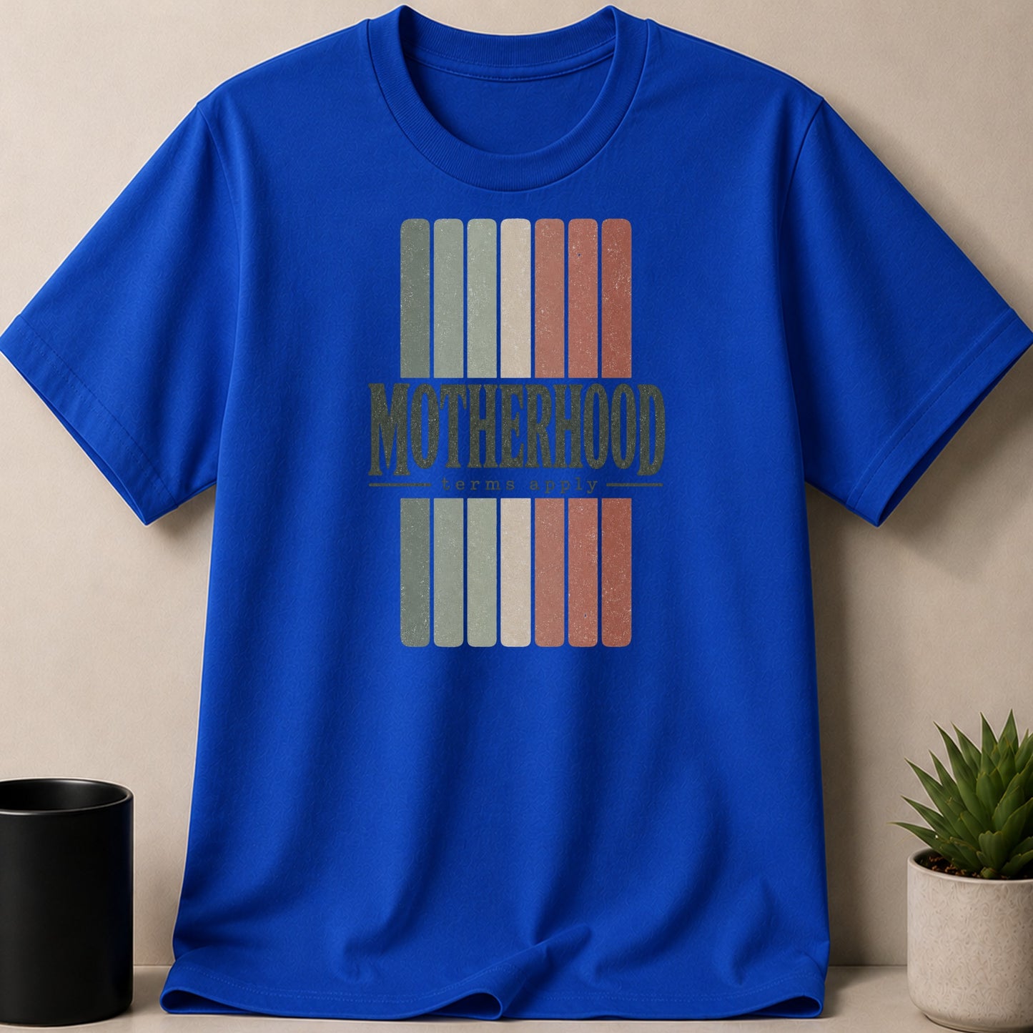Royal blue t-shirt with "Motherhood" and "terms apply" text in a vintage style.