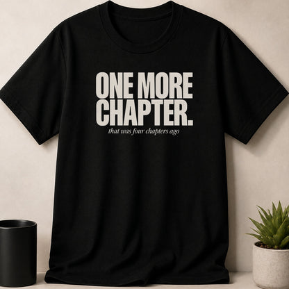 Black t-shirt with white text "ONE MORE CHAPTER that was four chapters ago".