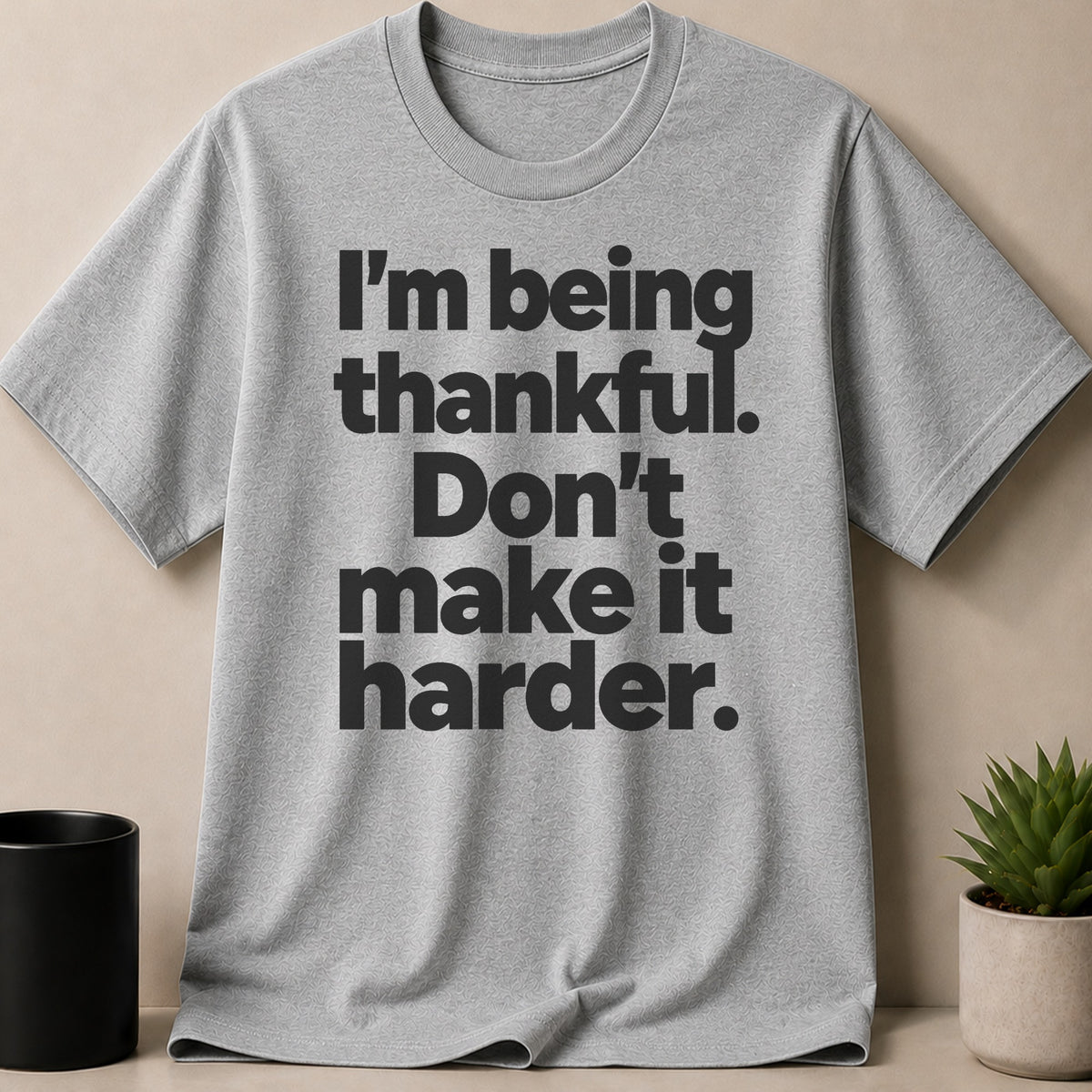 Grey t-shirt with black text reading "I'm being thankful. Don't make it harder."