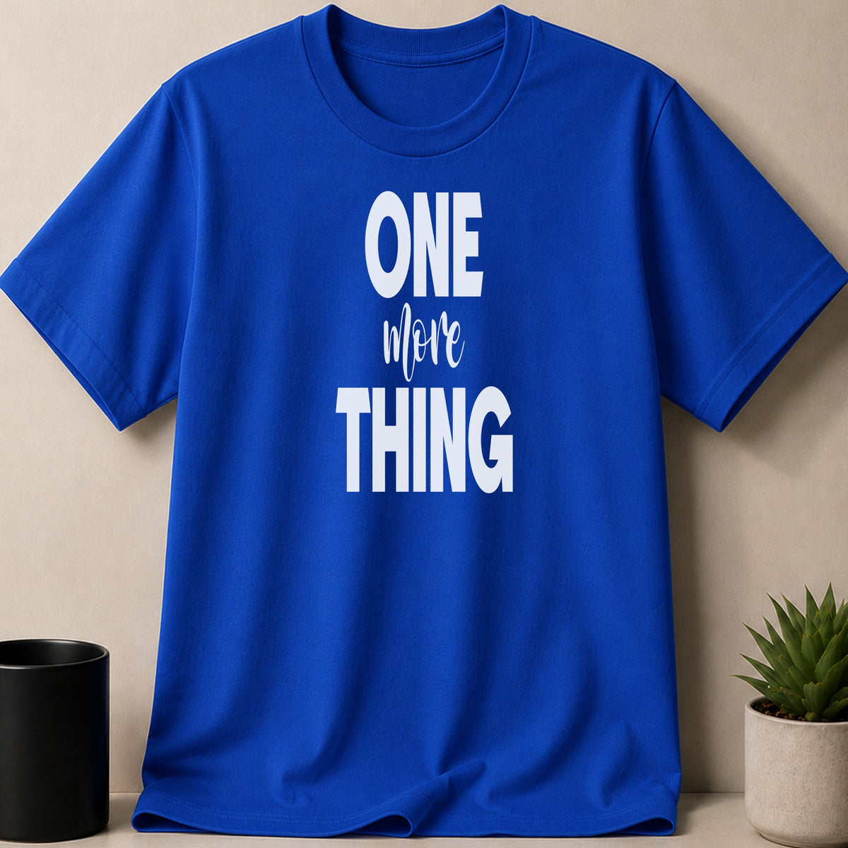 Blue t-shirt with white text that reads "ONE more THING".