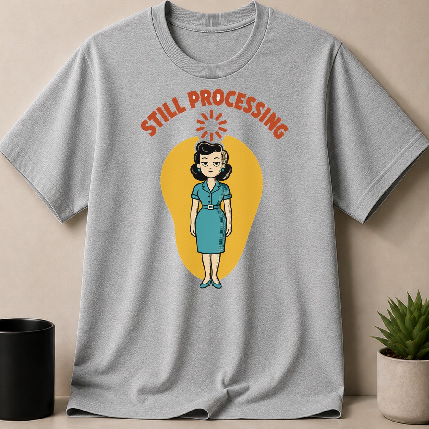 Gray t-shirt with cartoon of woman and text "STILL PROCESSING".